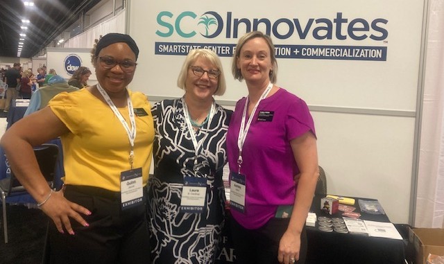 3 women standing in front of a table
