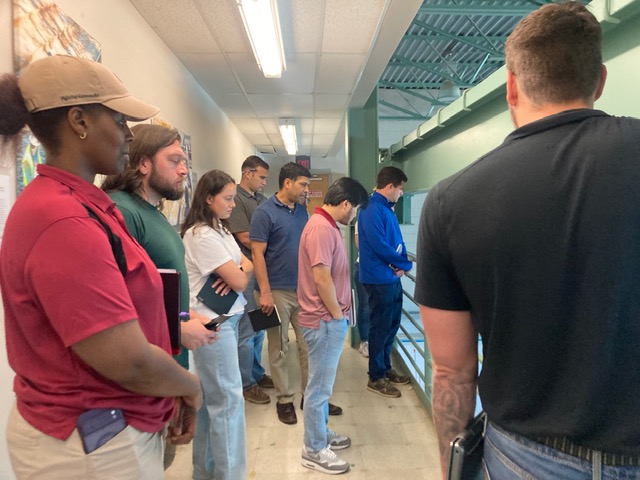 Group of people standing together looking at something off screen